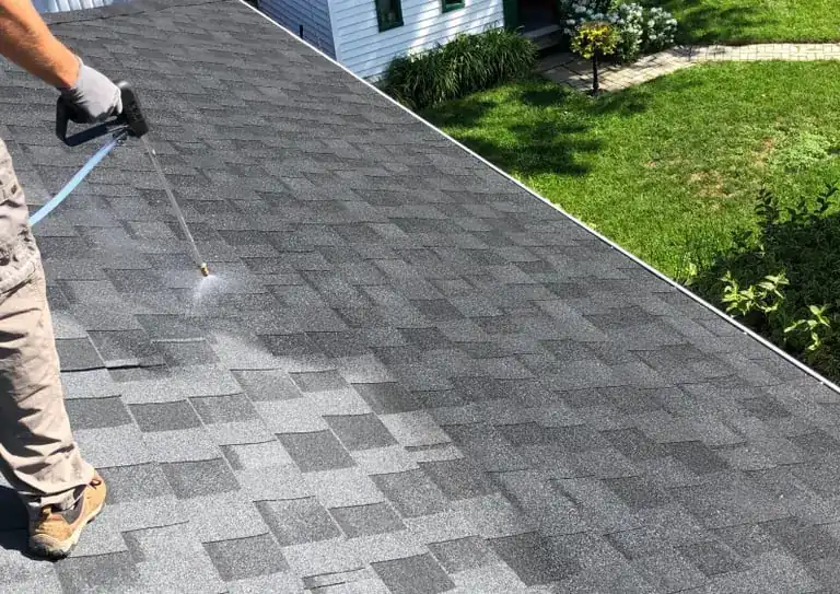 Roof treatment being applied to asphalt shingles